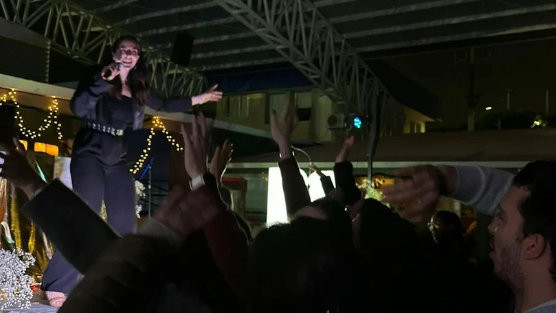 Mariana singing on stage with the audience gathered close