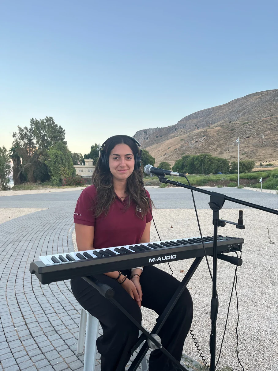 Mariana at a keyboard outdoors in Magdala